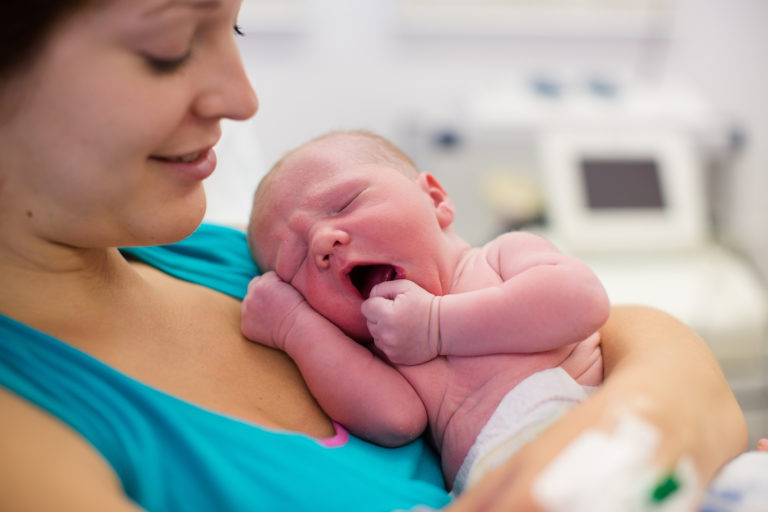 Young Mother Giving Birth To A Baby InsideSources