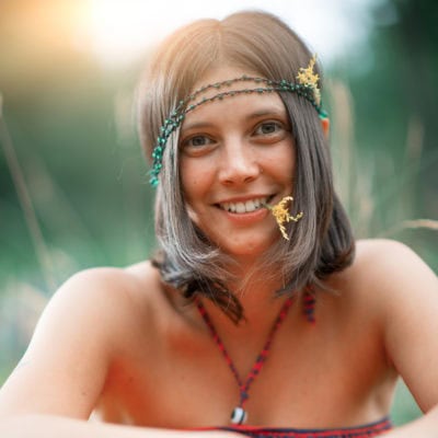 Portrait Of A Woodstock Hippie Style Girl. With Flower In The Mo
