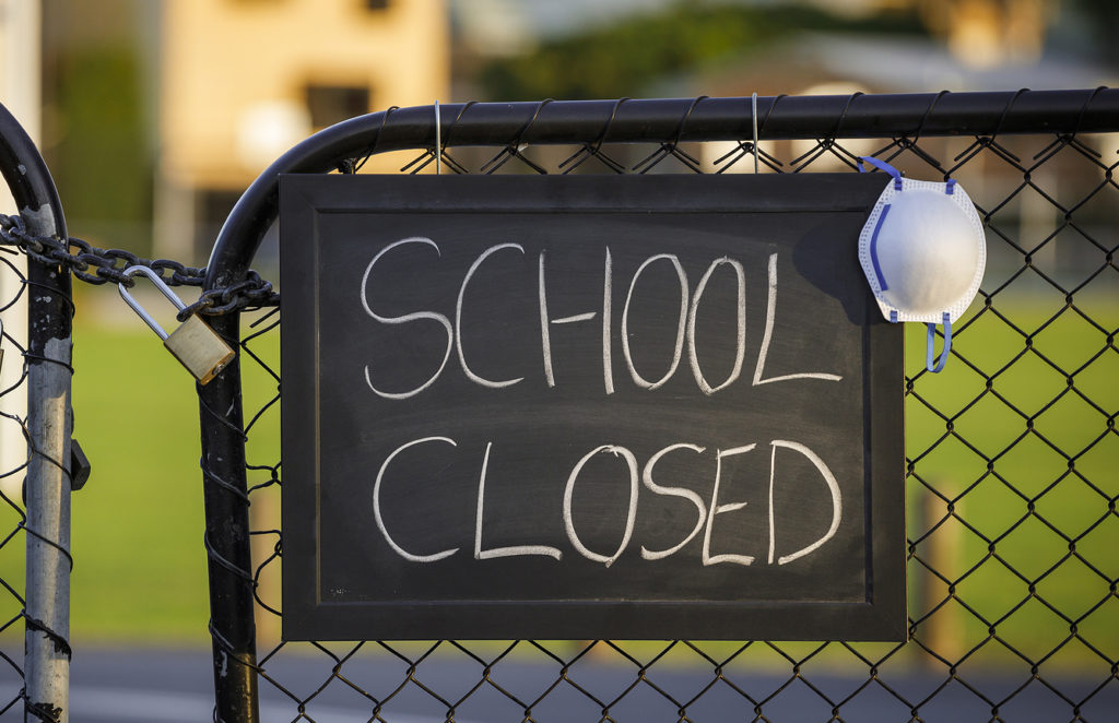 school-closed-sign-with-protective-mask-hanging-on-a-padlocked-g